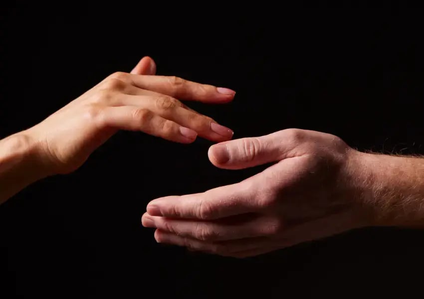 Photo of a man's hand and a woman's hand on a black background